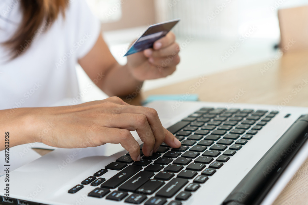 Woman holding credit card and using computer laptop, account and saving concept. Woman holding credit card and using computer laptop, account and saving concept.