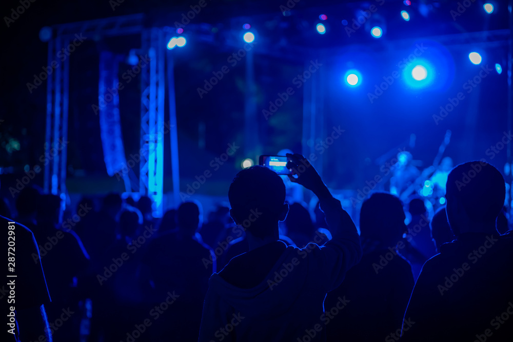Silhouette of the audience against the spotlights at concert