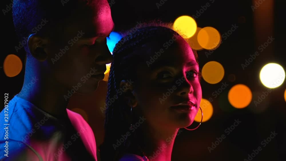 Young Afro-American boy hugging girlfriend from behind, enjoying night city view Young Afro-American boy hugging girlfriend from behind, enjoying night city view