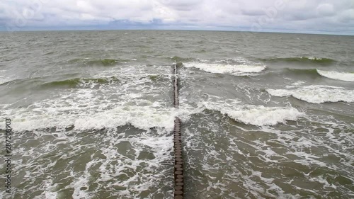 Wooden Breakwater in Sea. Old wooden breakwater in the sea extinguishes the waves