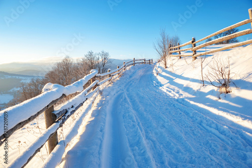 winter landscape. rural road covered with snow. mountainds on horizon © ver0nicka