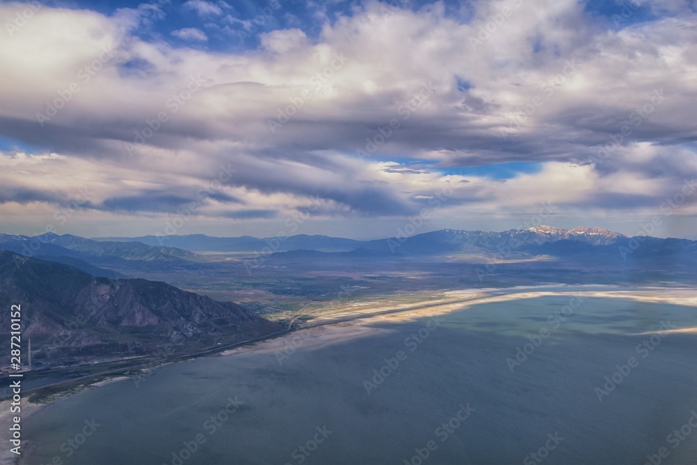 Great Salt Lake Utah Aerial view from airplane looking toward Oquirrh Mountains and Antelope Island, Tooele, Magna, with sweeping cloudscape. United States.