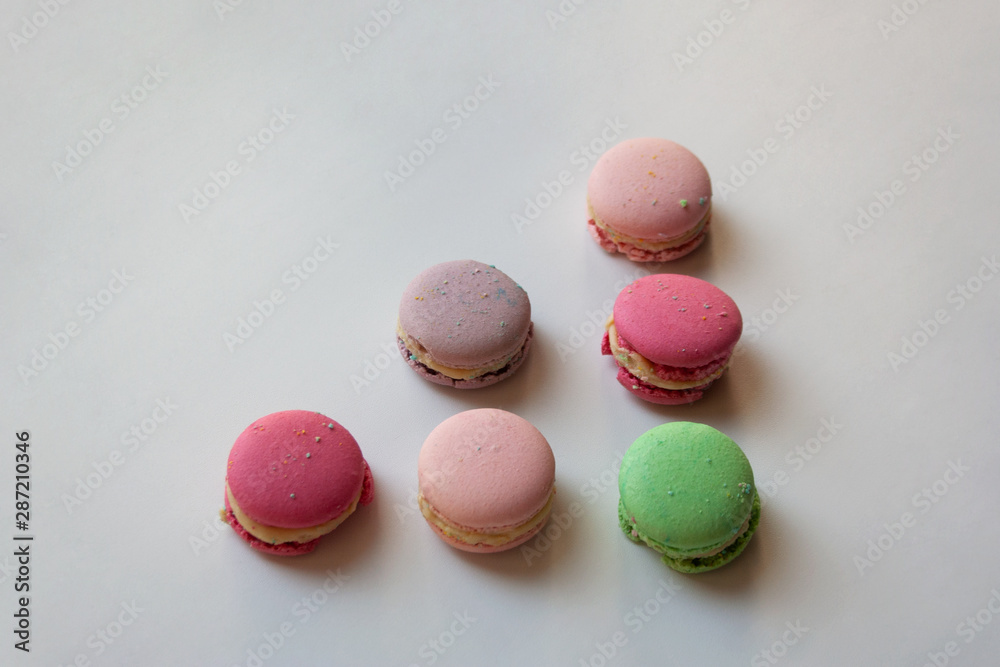 Obraz premium Colorful macaroon cakes triangle shaped composition isolated on white background