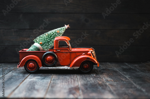 Red Toy Truck with a Christmas tree on a dark wood background