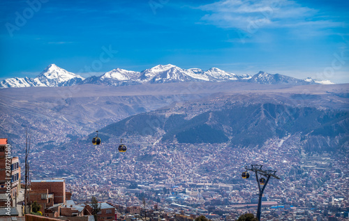 Cable cars in a panoramic view of the city of La Paz, Bolivia. Behind, you can see The Andes mountain range with peaks full of snow. Latin America