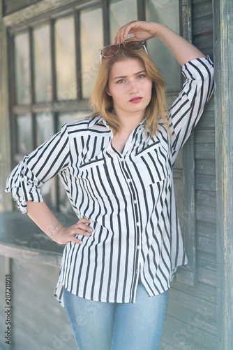 Portrait of a beautiful girl with bob haircut in a striped shirt walking outdoor © goldeneden