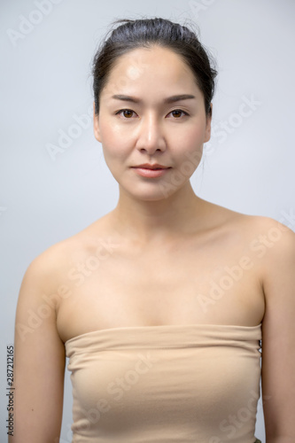 Asian woman beauty face closeup portrait. Beautiful attractive mixed race Chinese Asian / Caucasian female model with perfect skin isolated on white background