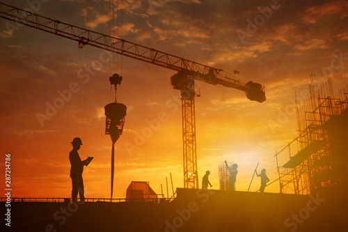 Silhouette of inspector working at construcktion on twilight background.