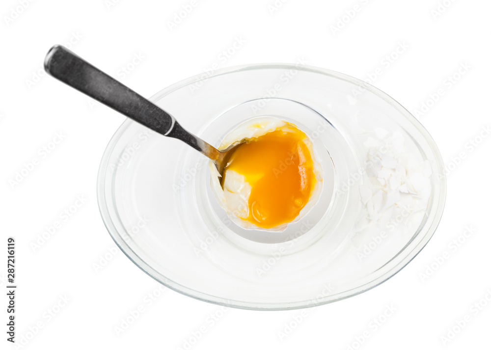 top view of open egg with spoon in glass egg cup top view of open egg with spoon in glass egg cup