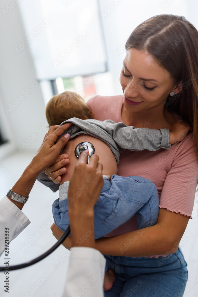 © lordn - Mother and her baby, visiting the doctor for a medical examination. Pediatrician doing an infant medical exam listening with a stethoscope. © lordn - Mother and her baby, visiting the doctor for a medical examination. Pediatrician doing an infant medical exam listening with a stethoscope.
