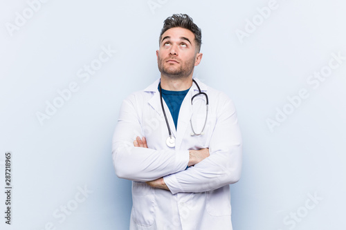 Young handsome doctor man tired of a repetitive task.