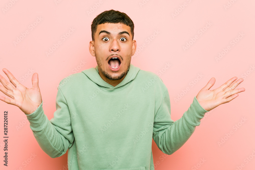 Young hispanic sport man celebrating a victory or success, he is surprised and shocked. Young hispanic sport man celebrating a victory or success, he is surprised and shocked.
