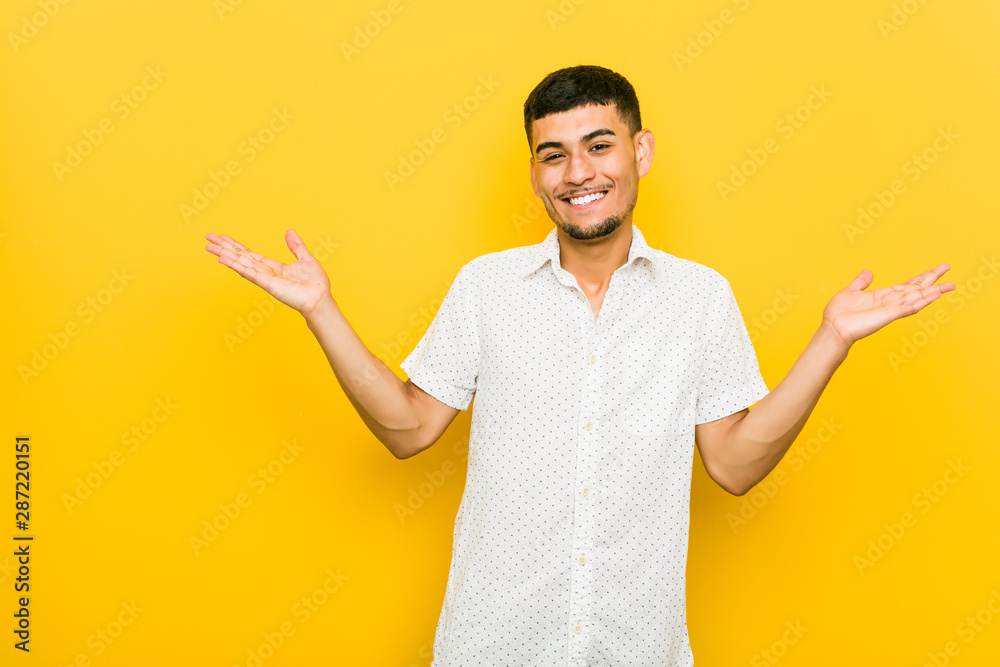 Young hispanic man doubting and shrugging shoulders in questioning gesture. Young hispanic man doubting and shrugging shoulders in questioning gesture.