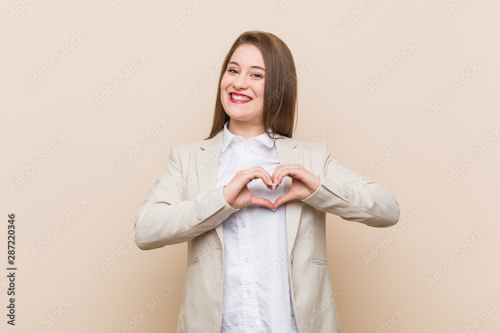Young business woman smiling and showing a heart shape with hands. Young business woman smiling and showing a heart shape with hands.