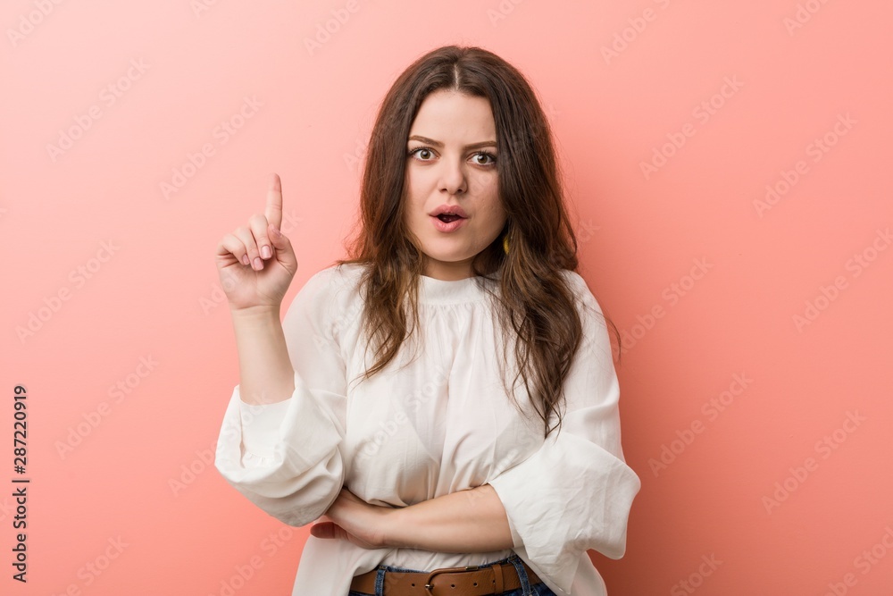 Young caucasian curvy woman standing against pink background Young caucasian curvy woman standing against pink background