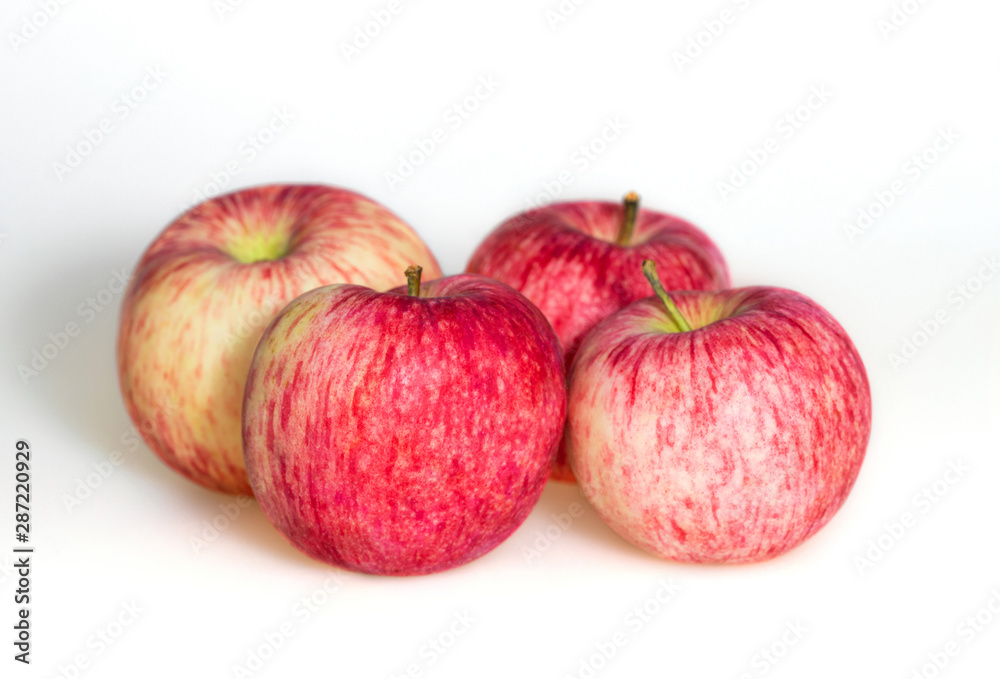 Four apples on white background. Red juicy ripe apples close up. Fresh striped fruit. Side view. Four apples on white background. Red juicy ripe apples close up. Fresh striped fruit. Side view.