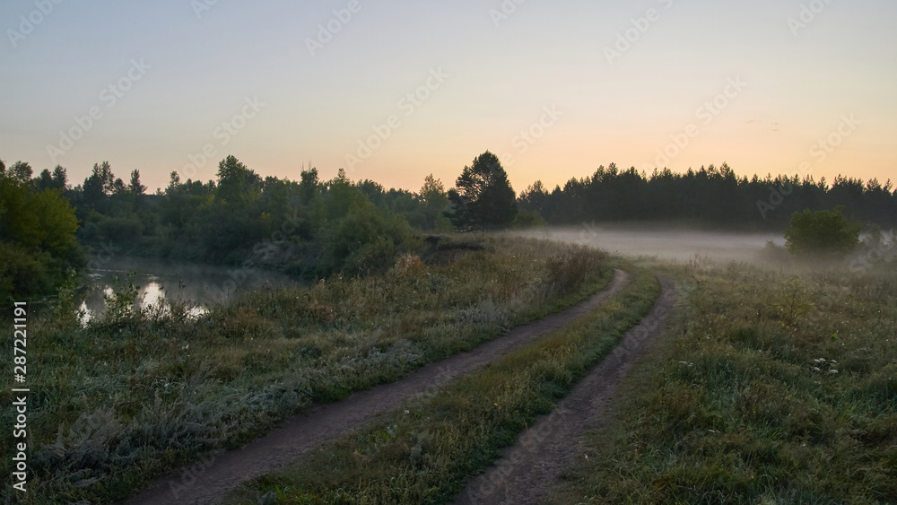 Fototapeta premium A quiet dawn over the lake in a Sunny hazy light. Autumn time.