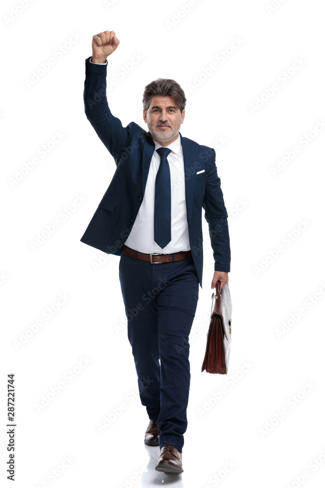 Successful businessman holding his suitcase and celebrating Successful businessman holding his suitcase and celebrating