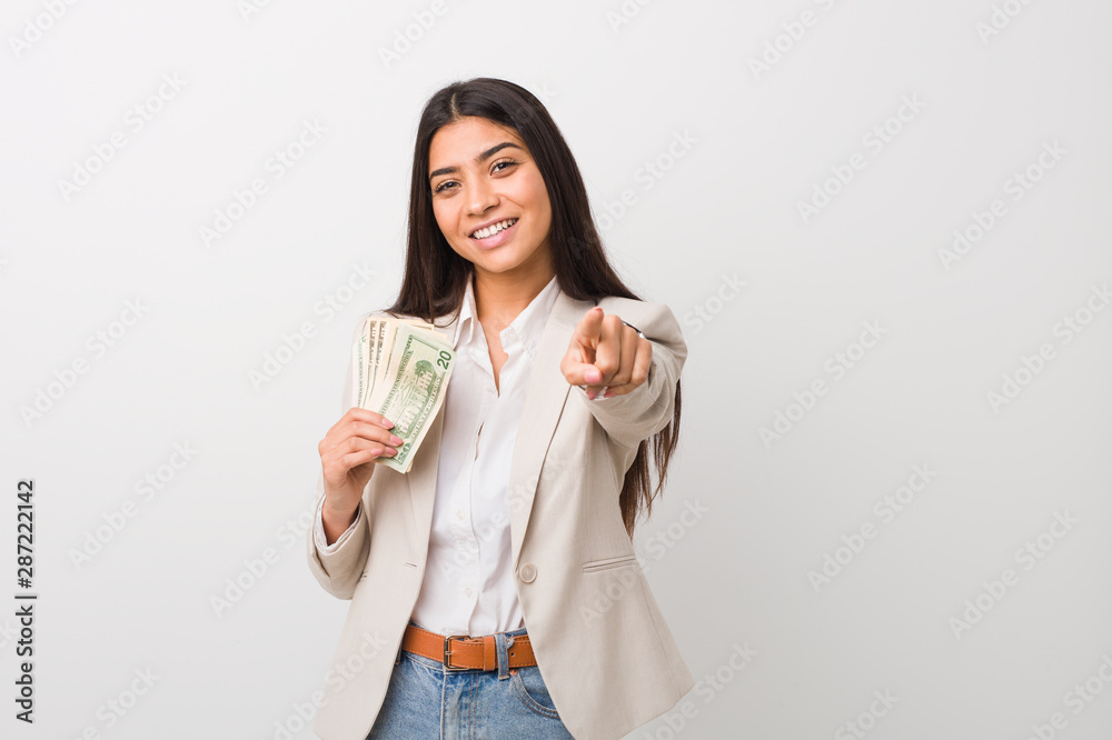 Young arab business woman holding dollars cheerful smiles pointing to front. Young arab business woman holding dollars cheerful smiles pointing to front.