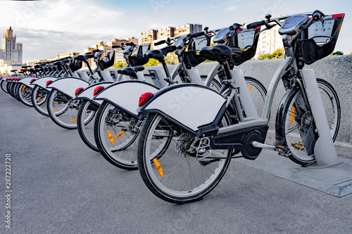 .Bicycles stand in a row in a parking lot for rent.