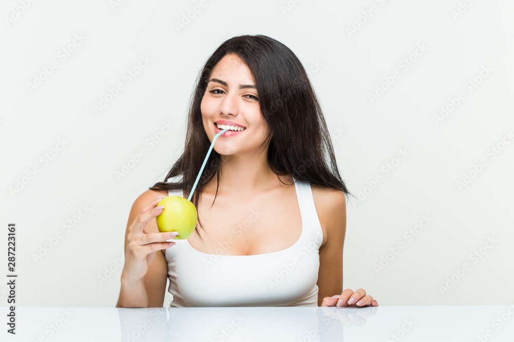 Young hispanic woman drinking an apple juice with a straw Young hispanic woman drinking an apple juice with a straw