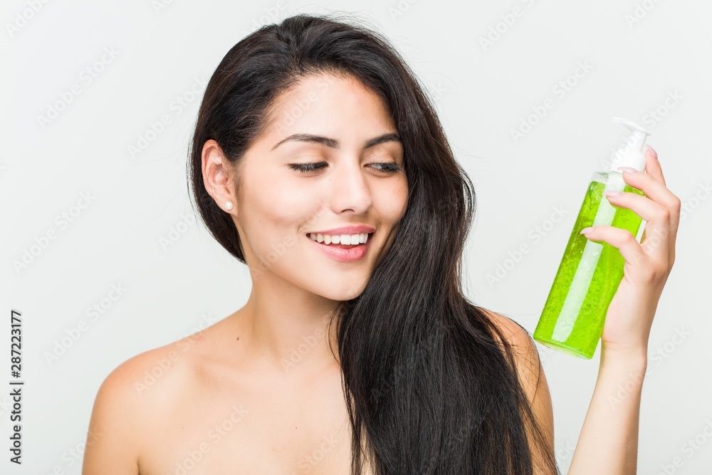 Close up of a young beautiful and natural hispanic woman holding an aloe vera bottle Close up of a young beautiful and natural hispanic woman holding an aloe vera bottle