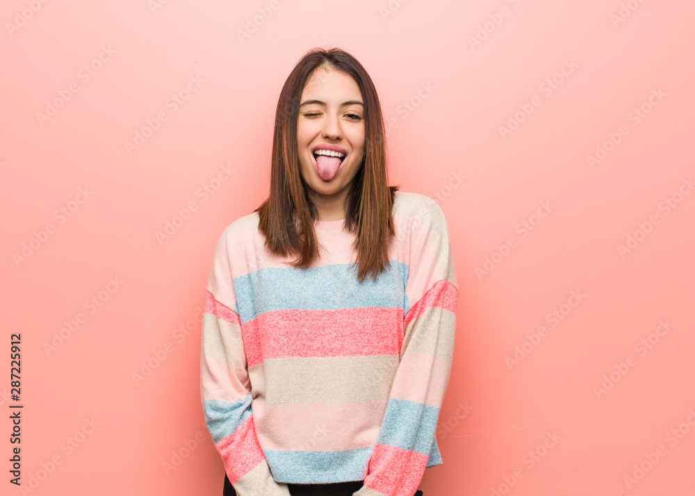Young cute woman funnny and friendly showing tongue - obrazy, fototapety, plakaty 