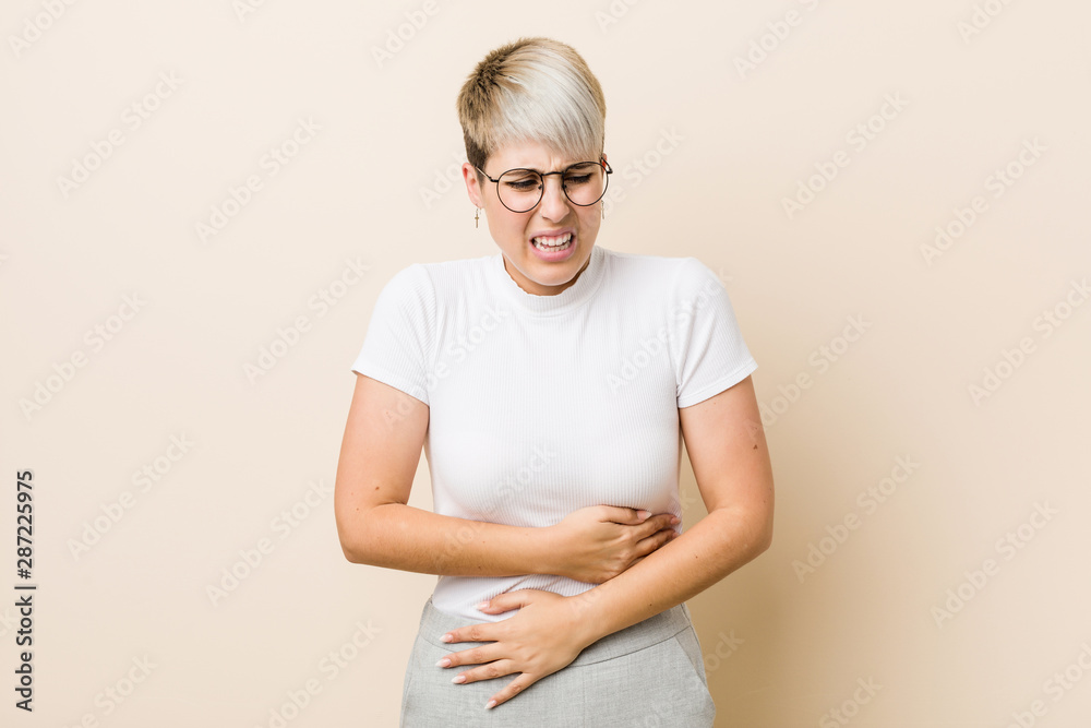 Obraz premium Young authentic natural woman wearing a white shirt sick, suffering from stomachache, painful disease concept.