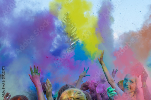 Begeisterte Kinder auf einem Holi Fest tanzen und werfen mit buntem Farbpulver	 photo