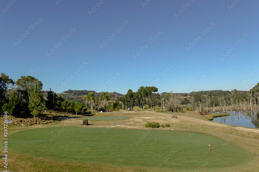 Campo de golfe com árvores e céu azul