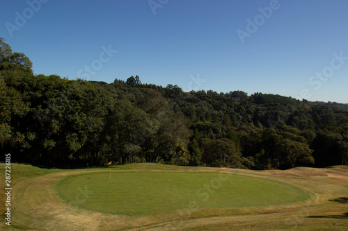 Campo de golfe com árvores e céu azul