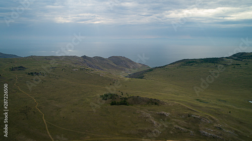 Baikal region. Dirt road on Tazheranskaya steppe near the stone rocks, called the Valley of the Stone Spirits. Aerial