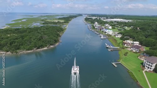 Large White Catamaran Enters Taylors Creek Beaufort, North Carolina. Luxurious Aerial Drone Shot photo