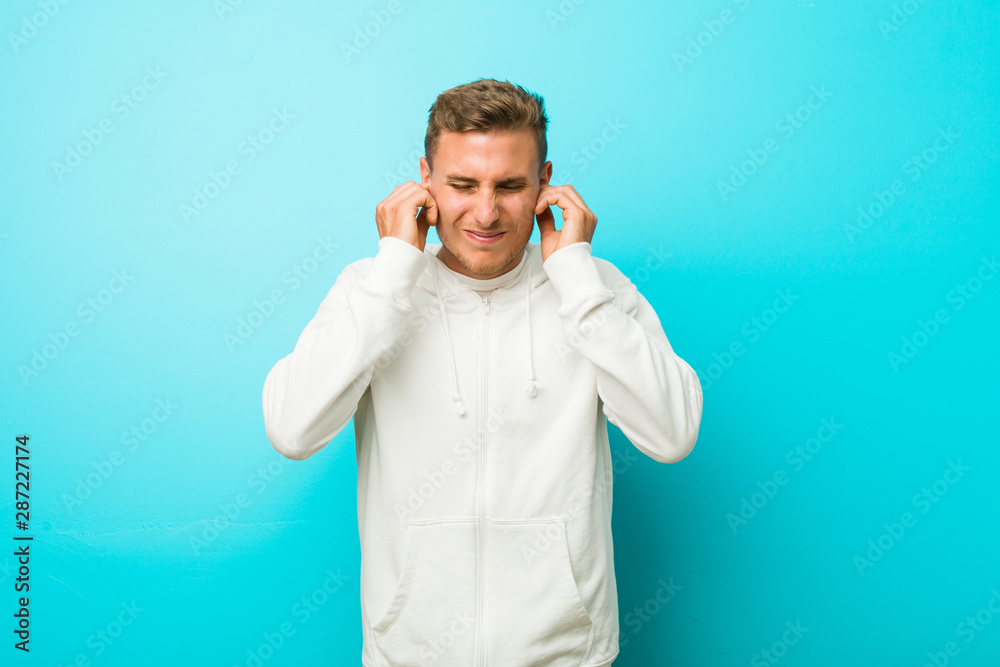 Young caucasian sport man covering ears with hands.
