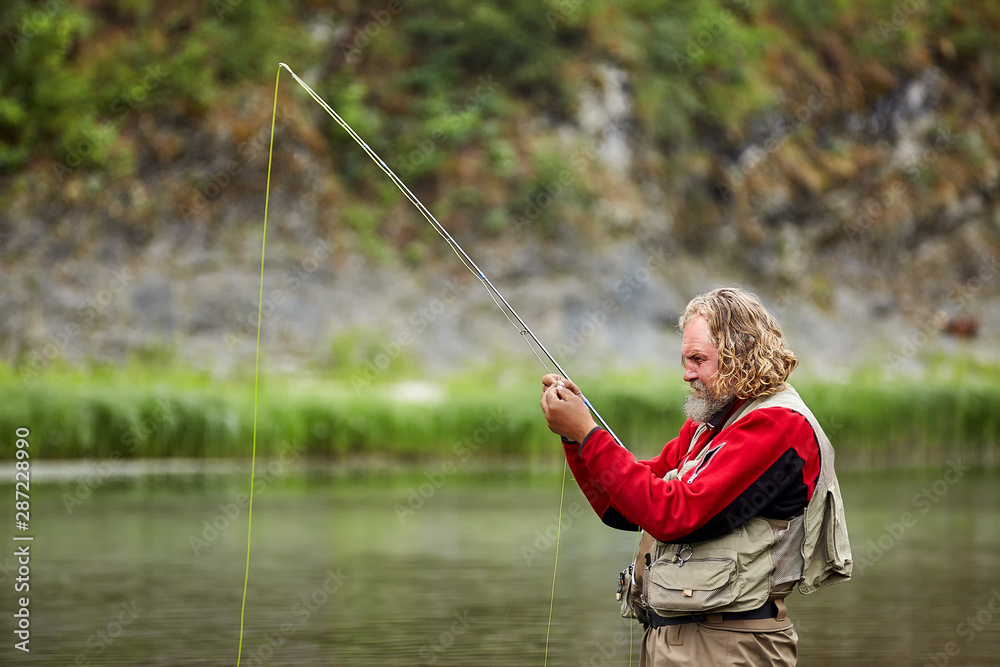 Fisherman casting catches fish in the river. Fisherman casting catches fish in the river.
