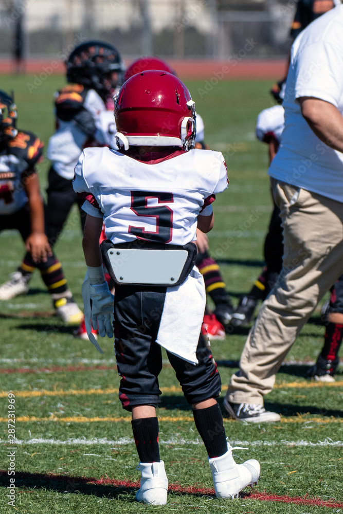 Youth football player number 5 stands on turf ready to play. Youth football player number 5 stands on turf ready to play.