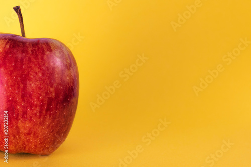 Half red apple on yellow background, fresh fruit, juicy fruit, macro apple