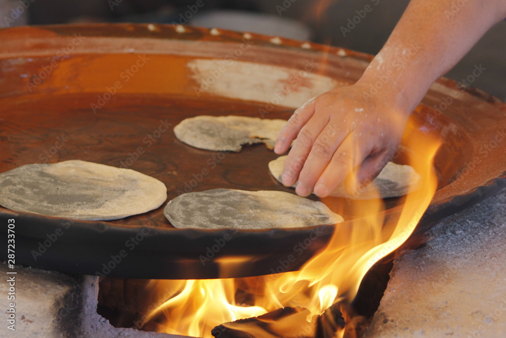 Hands of indigenous women making blue corn dough in a traditional way
