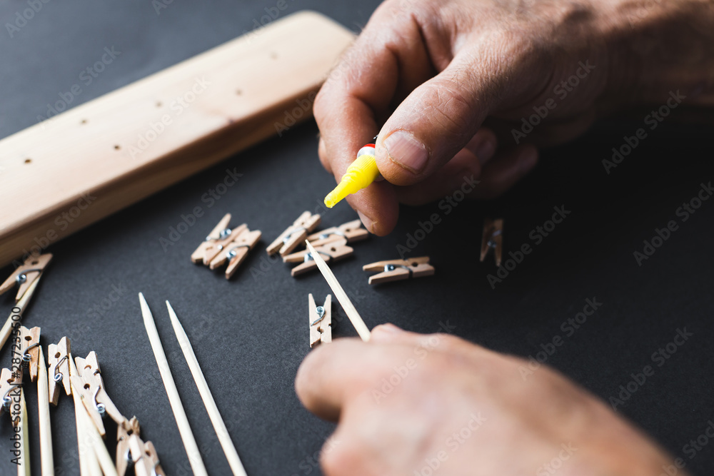 Fototapeta premium glue together wooden clothespins and sticks, make a holder for photos