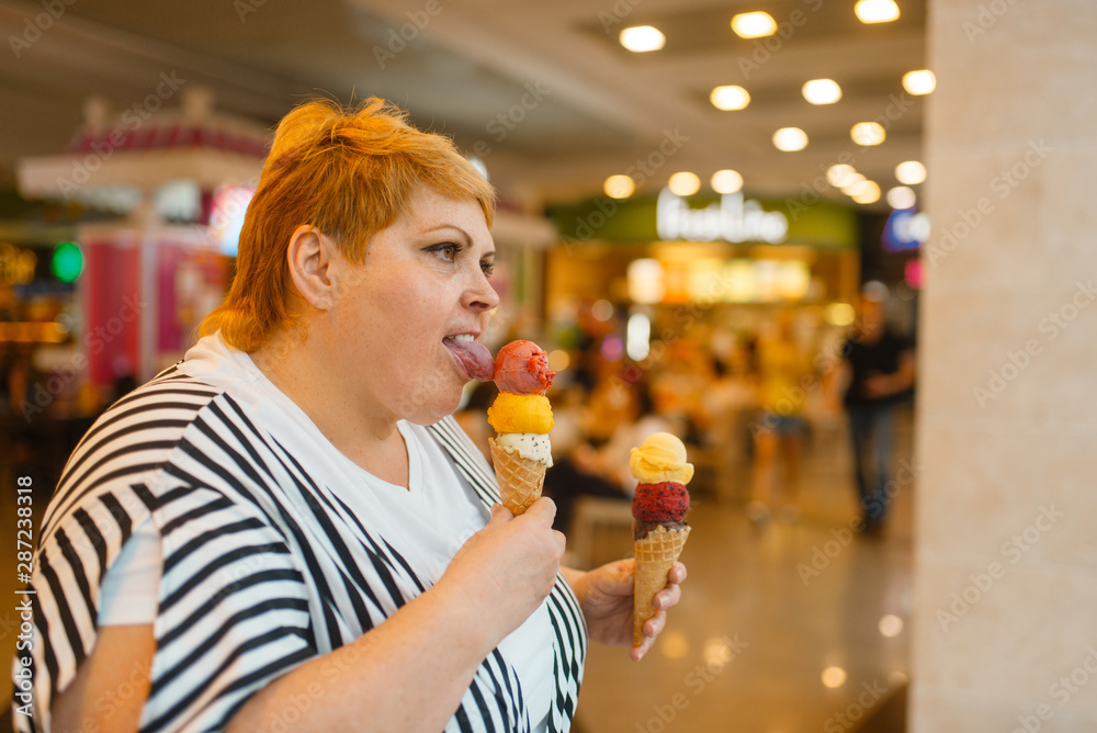 Fat woman eating two ice creams, fastfood Fat woman eating two ice creams, fastfood