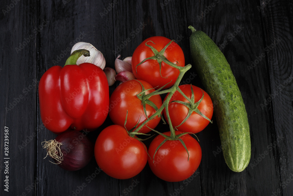 branch with tomatoes, cucumber, onion and garlic on wooden background. top view branch with tomatoes, cucumber, onion and garlic on wooden background. top view