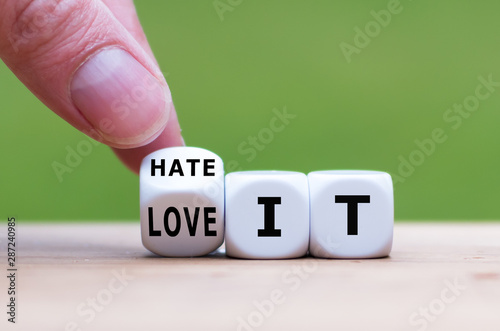 Hand turns a dice and changes the expression "hate it" to "love it".