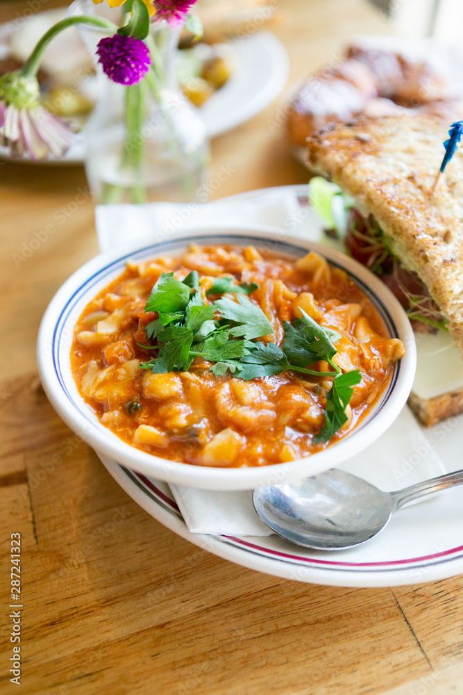 Close up of minestrone soup with california club sandwich on cafe table Close up of minestrone soup with california club sandwich on cafe table