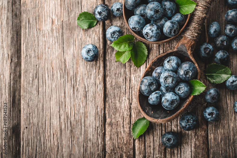 Blueberries in wooden spoon on old wood background. Healthy eating and nutrition concept. Blueberries in wooden spoon on old wood background. Healthy eating and nutrition concept.