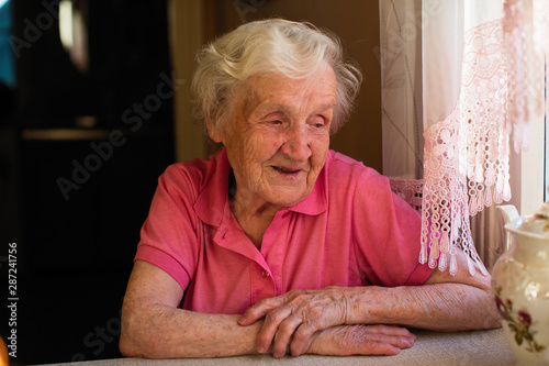 Elderly woman sitting at the table.