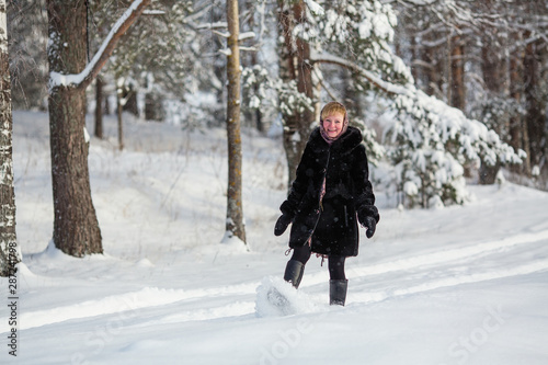 Young woman at winter in the snowy forest.
