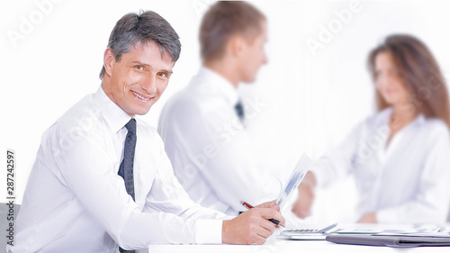 Smiling businessman and businesswoman shaking hands over conference table