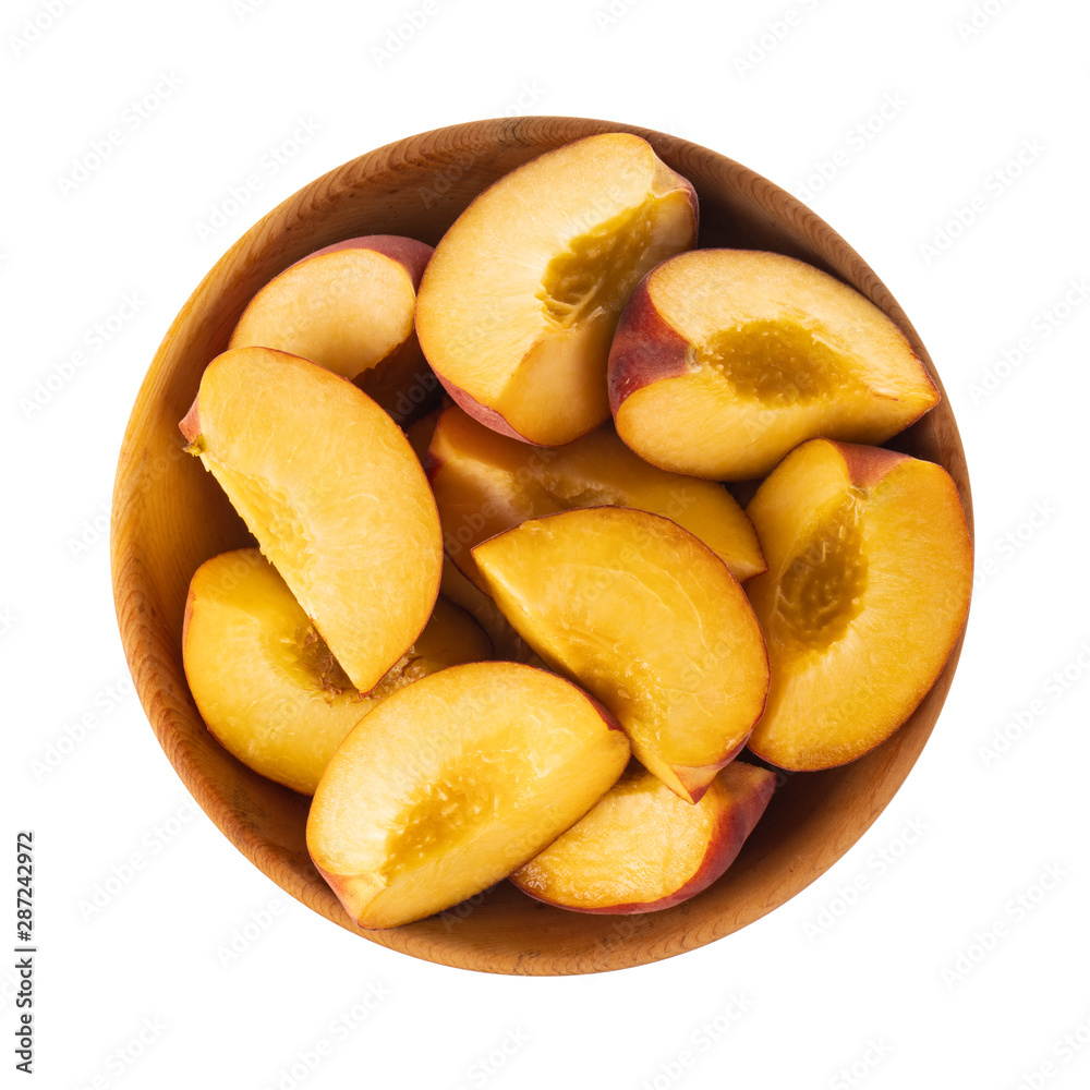 heap of slices peach in wooden plate isolated on white background. top  view