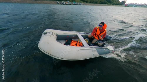 Young man riding motorboat on river. Man floats on a motorboat photo