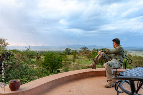 man sitting and watching serengeti